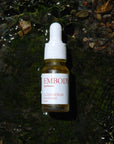 Travel size 10ml Cloud Serum, handcrafted in Montreal using sustainable Canadian ingredients, sits in a river near Quebec.