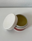 Open jar of Miracle Salve sitting on a white table