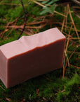 The handcrafted Rose Geranium soap bar sits on a bed of moss.