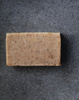 The speckled Coffee Scrub soap sits on a display.