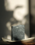 The all-natural and lightly exfoliating Activated Charcoal Facial Soap sits in the sunshine.