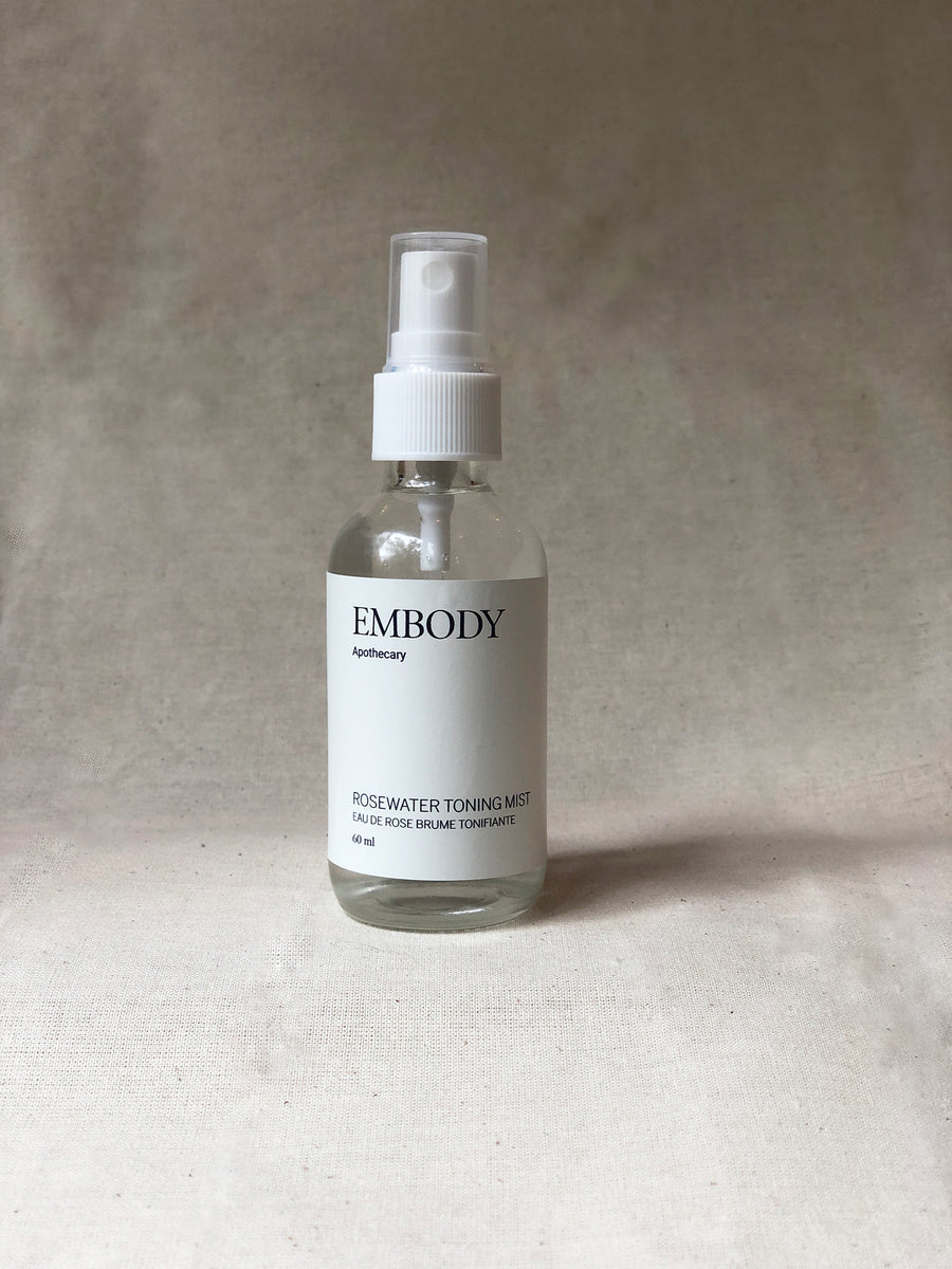 The organic Rosewater Facial Toning Mist, made with pure Rose hydrosol, sits in front of a beige background.
